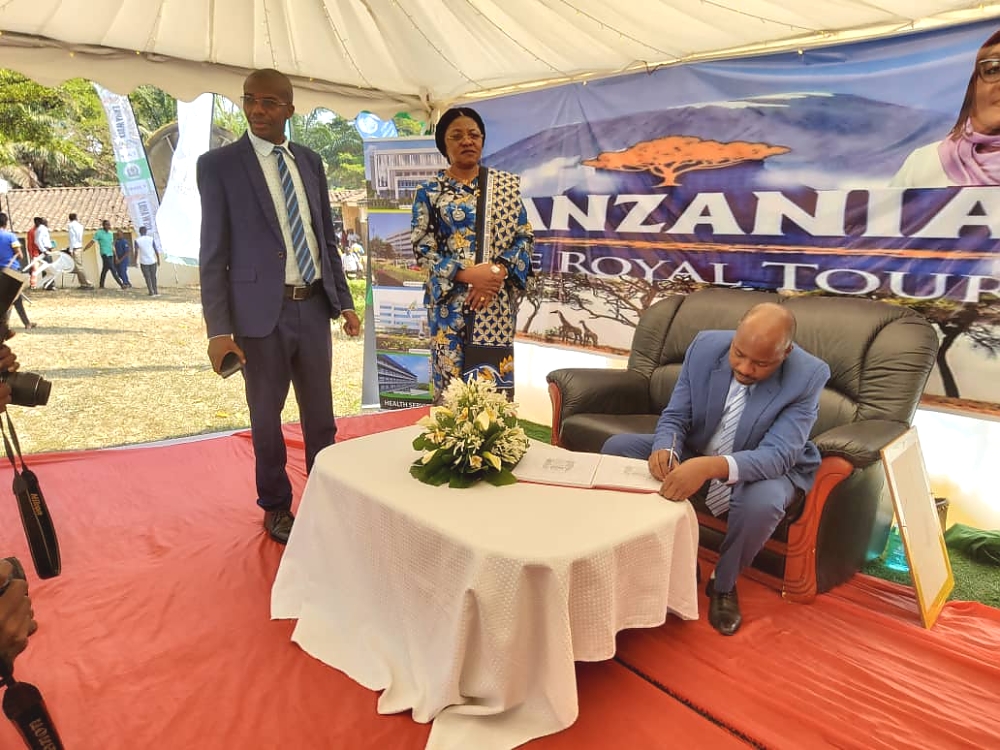 MGENI RASMI BW. JEAN CLAUDE KANENE AKITIA SAINI KWENYE KITABU CHA WAGENI ALIPOTEMBELEA BANDA  LA MAONESHO  LA UBALOZI WAKATI WA MAADHIMISHO.